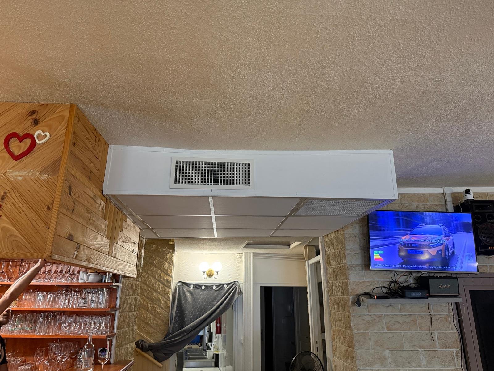 Caisson de climatisation gainable et grille de soufflage au plafond de la salle d'une pizzeria